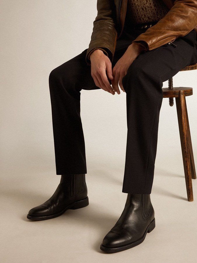 Man seated wearing LUCIAN black leather Chelsea boots